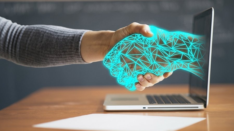 Eine Hand greift eine digitale Hand aus einem Notebook © Kiquebg über Pixabay