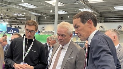 Im Detail: Projektleiter Daniel Hornung (Raumideen/ONOX) erläutert Bundesminister Alois Rainer (BMLEH) und Referatsleiter Stephan Sanders (BLE, Referatsleitung Innovationsförderung Pflanzenbau, Verbraucherschutz) das Konzept des elektrischen Traktors. © BLE